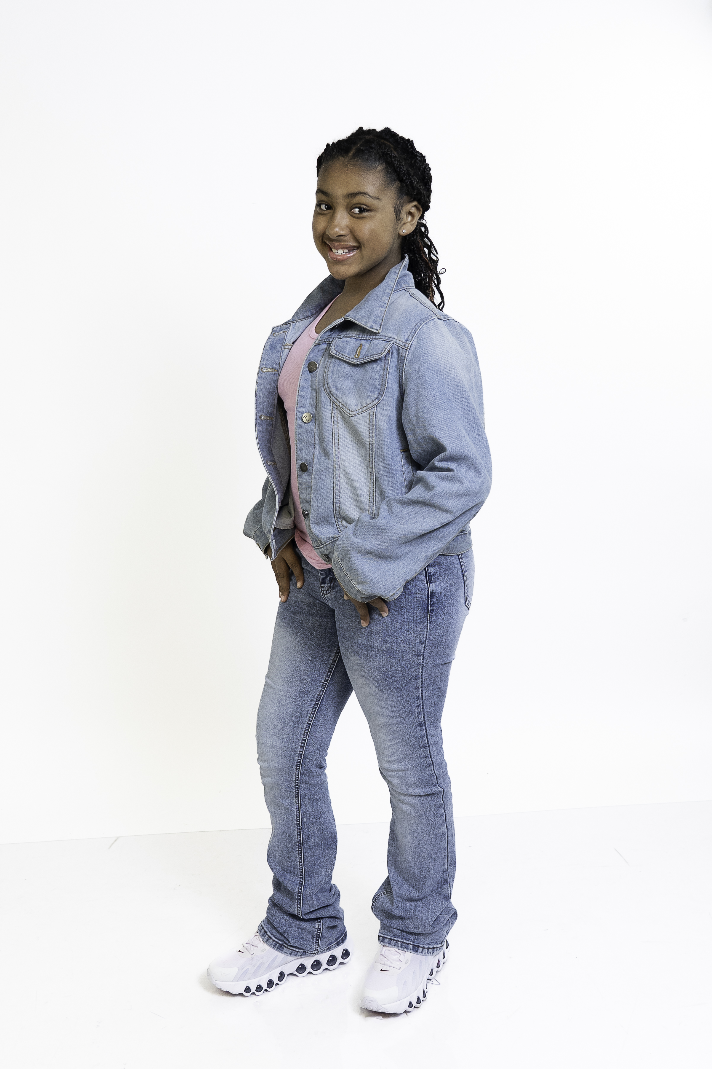 Eleaya Neveah full-body photo, standing with a big smile in a denim jacket and jeans